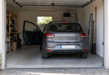 Coche pequeño estacionado en un garaje doméstico con la puerta del conductor abierta y espacio para salir.